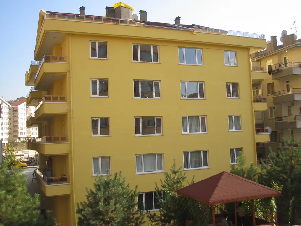 Ankara'da balkonlu, sarı cepheli beş katlı bir apartman