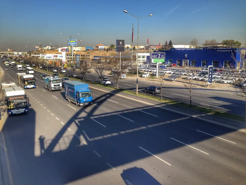 Yaya köprüsünden görülen çok şeritli bir yolda otobüsler ve otomobiller
